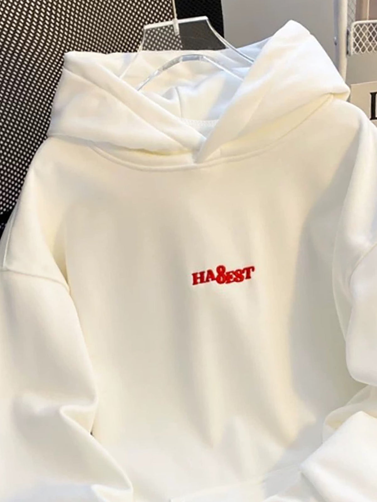 Weißer Hoodie mit rotem Schriftzug und Motiv